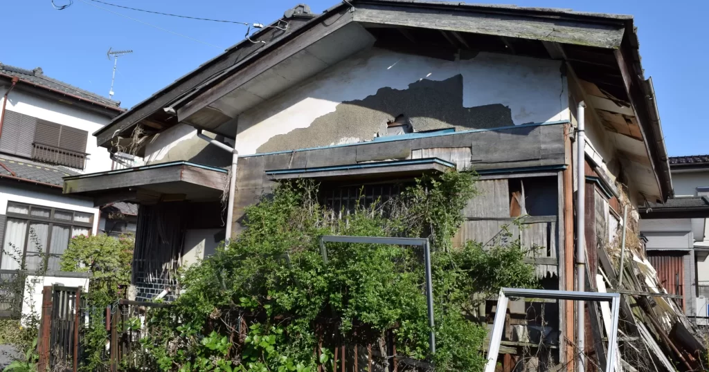 瓦がずれ草の茂った傷んだ空き家